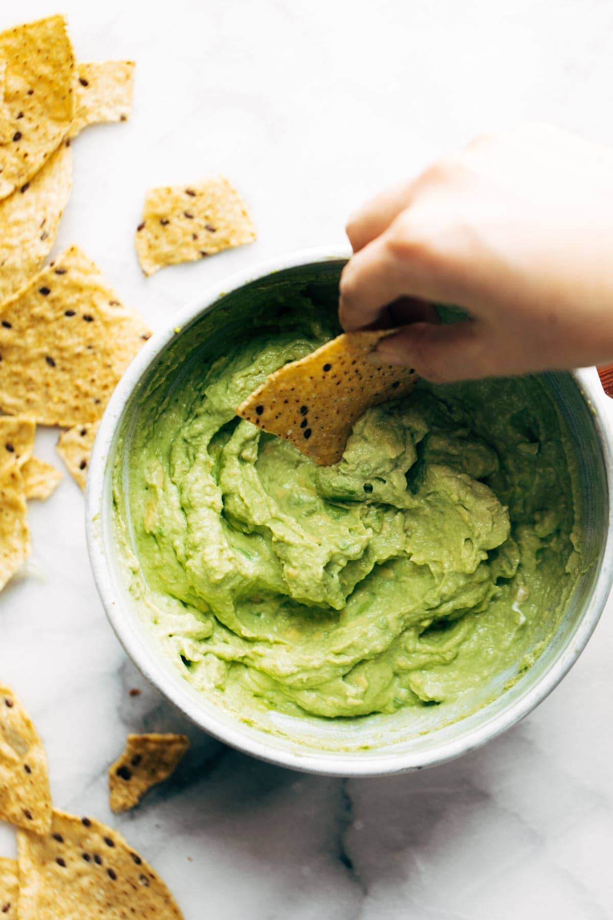 A bowl of avocado dip with chips for serving