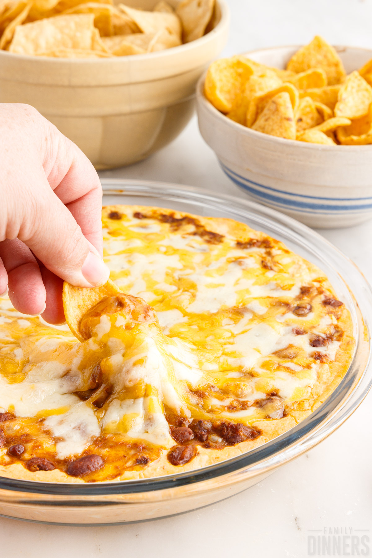 Chili cheese dip on a plate with chips and crackers for dipping