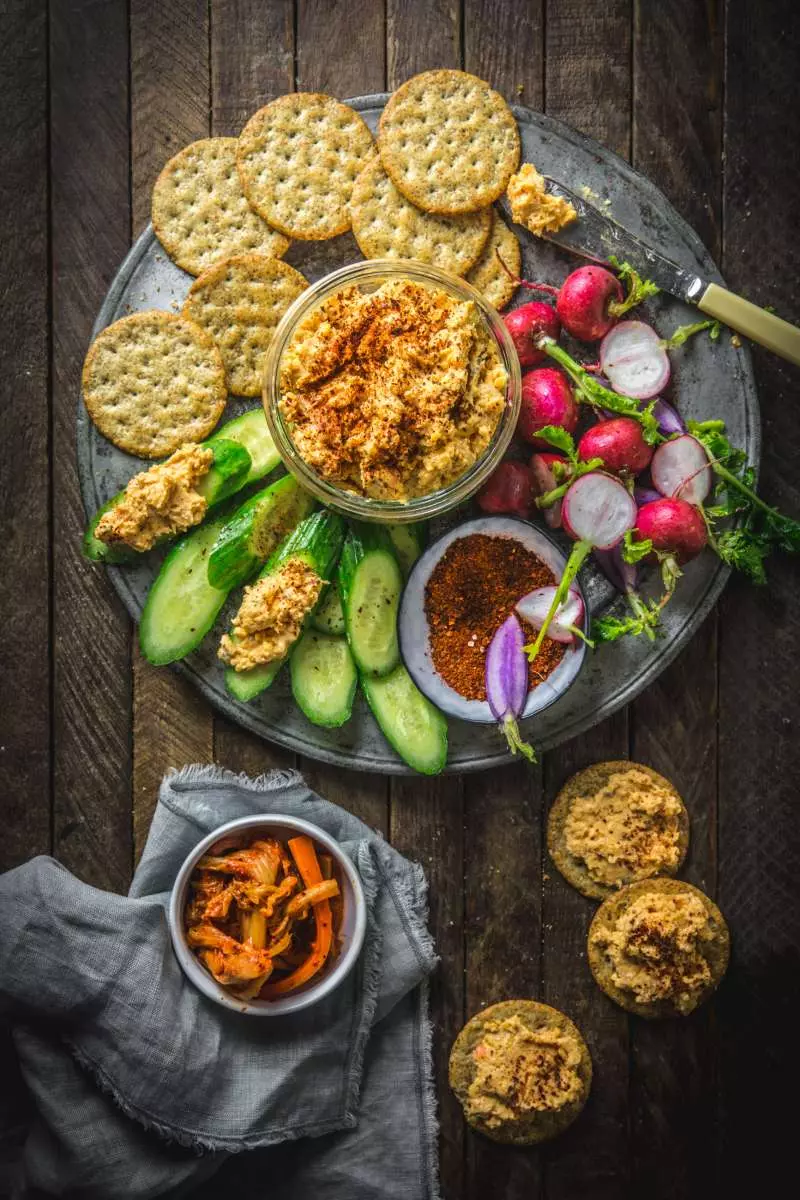 Bowl of dip on a platter with crackers and veggies for dipping