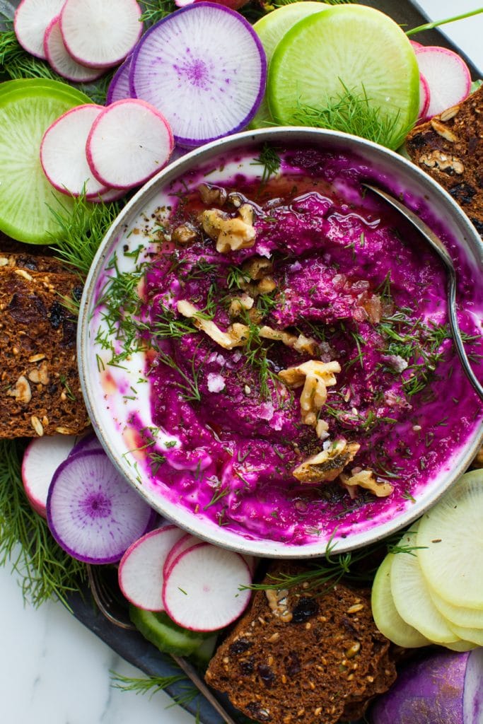 Roasted beets dip in a bowl with veggies and crackers for dipping