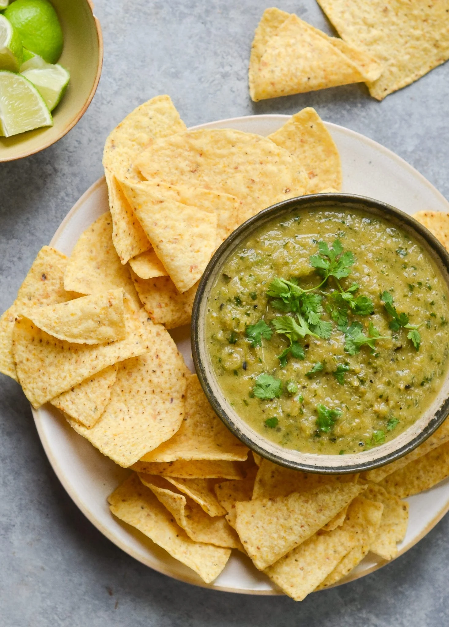 Bowl of salsa verde and tortilla chips on a plate